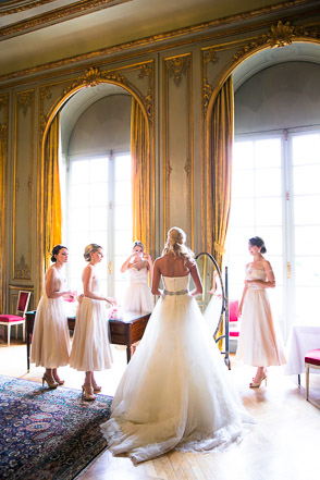 Bride with bridesmaids by beautiful french chateau windows 