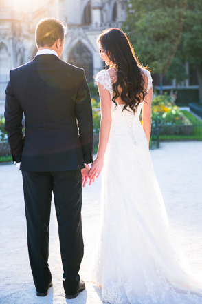 Backs of bride and Groom holding hands at Notre Dame
