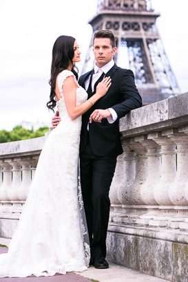 Groom embraces bride with Eiffel Tower in background