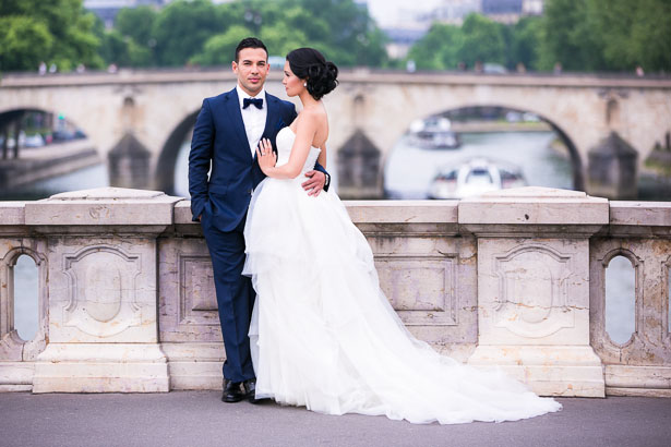 Groom and Bride Leaning on Paris Bridge Railing