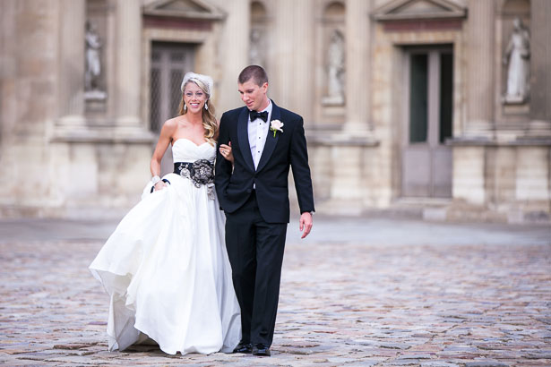 Bride and Groom Walk on Cobblestones Outside Louvre