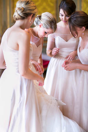 Bridesmaids Opening Wedding Gown for a Bride