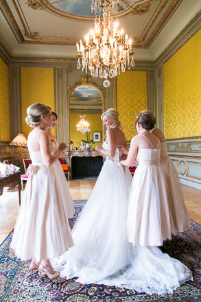 Bridesmaids Fasten Gown of Bride in Beautiful Chandeliered Chateau 