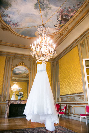 Wedding Gown Hanging From a Chandelier of Chateau With Ceiling Fresco