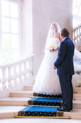 Veiled Bride Descends a Grand Staircase Towards Her Father